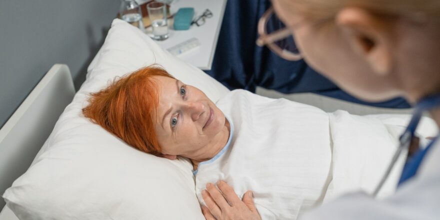 Elderly woman talking to doctor at hospital
